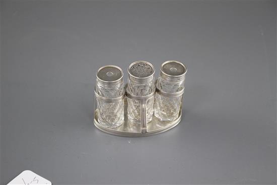 A George III silver oval ink bottle stand, London, 1799 (no makers mark), with three later Victorian silver monted glass bottles